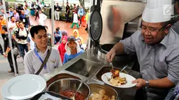 Presdir Aksi Cepat Tanggap Ahyudin saat melayani masyarakat yang mengantre untuk mengambil makanan di Food Truck di halaman masjid Istiqlal Jakarta, Rabu (24/5). (Liputan6.com/Hardi)