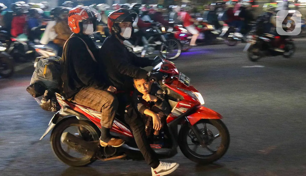 Pemudik yang menggunakan sepeda motor melintas di Jalan Raya Kalimalang, Bekasi, Jawa Barat, Rabu (19/4/2023) malam. (Liputan6.com/Herman Zakharia)
