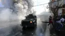 Polisi menyemprotkan gas air mata untuk membubarkan unjuk rasa yang berlangsung ricuh di sekitar Kongres di Valparaiso, Chili. Sabtu (21/5). (AFP Photo/Claudio Reyes)