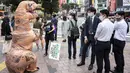 Aktivis kelompok hak hewan PETA mendesak orang untuk menjadi vegan selama protes di Tokyo, Jepang, Rabu (6/10/2021). Dalam aksinya, para aktivis mengenakan kostum dinosaurus. (CHARLY TRIBALLEAU/AFP)