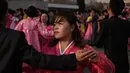 Sejumlah siswa berpasang-pasangan melakukan tarian massal di luar Stadion Indoor Pyongyang, Korea Utara (9/4). Mereka melakukan tarian massal untuk menghormati pemimpin mereka Kim Jong Il. (AFP Photo/Ed Jones)