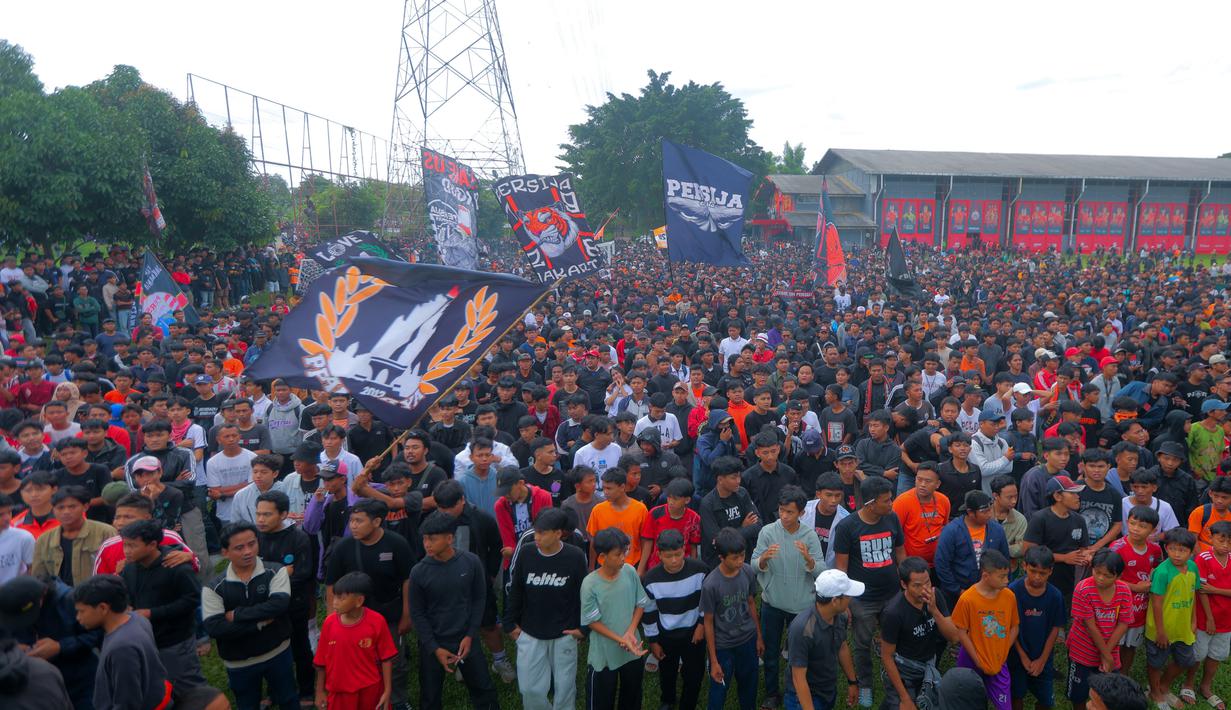 Mereka hadir untuk memberikan dukungan penuh kepada Persija Jakarta jelang lawan Persib Bandung. Tampak dalam foto, ribuan pendukung Persija Jakarta atau The Jakmania memenuhi Persija Training Ground, Bojong Sari, Depok, Jawa Barat, Jumat (9/1/2026). (Bola.com/M Iqbal Ichsan)