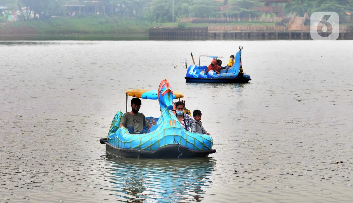 Warga berkeliling dengan menggunakan perahu wisata di Setu Babakan, Jagakarsa, Jakarta Selatan, Minggu (4/4/2021). Kios yang boleh dibuka bergantian dengan sistem tanggalan ganjil genap. (merdeka.com/Arie Basuki)