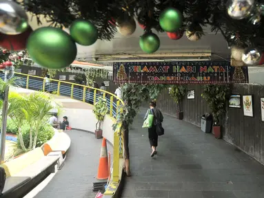 Pejalan kaki melintasi ornamen Natal yang menghiasi tempat penyeberangan orang (TPO) Kota Tua, Jakarta, Kamis (20/12). TPO yang menghubungkan Stasiun Kota Tua dan Halte Transjakarta tersebut berhias ornamen Natal dan Tahun Baru. (Merdeka.com/IqbalNugroho)