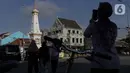 Pesepeda berfoto di perempatan Tugu Pal Putih Yogyakarta, Sabtu (26/12/2020). Kini, proses penataan kembali kawasan Tugu Pal Putih Yogyakarta rampung dilakukan, dan area yang menjadi salah satu ikon kota Yogya terlihat lebih rapi tanpa gangguan kabel melintang. (Liputan6.com/Helmi Fithriansyah)