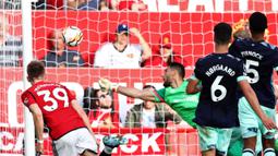 Pemain MU, Scott McTominay (kiri), berhasil mencetak gol kedua ke gawang Brentford yang dijaga oleh Thomas Strakosha dalam pertandingan pekan kedelapan Liga Inggris 2023/2024 yang berlangsung di Old Trafford, Sabtu (8/10/2023). McTominay yang baru dimainkan Erik Ten Hag pada menit ke-87 berhasil mencetak dua gol pada menit 90+3 dan 90+7. (AFP/Darren Staples)
