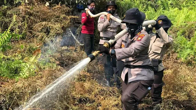 Proses pemadaman kebakaran lahan yang dilakukan polisi wanita di Polres Indragiri Hilir.