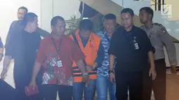Bupati Jombang Nyono Suharli Wihandoko (tengah) usai menjalani pemeriksaan pasca terkena OTT di Gedung KPK, Jakarta, Minggu (4/2). Nyono menjadi tersangka dalam dugaan suap perizinan pengurusan jabatan di Pemkab Jombang. (Liputan6.com/Helmi Fithriansyah)