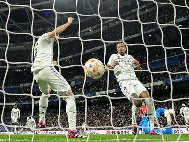 Pemain Real Madrid, Eder Militao (tengah) mencetak gol bunuh diri pada laga leg pertama semifinal Copa Del Rey 2022/2023 melawan Barcelona di Santiago Bernabeu, Madrid, Jumat (03/03/2023) WIB. Gol ini menjadi satu-satunya gol yang berhasil memenangkan Barcelona dengan skor 1-0. (AFP/Javier Soriano)