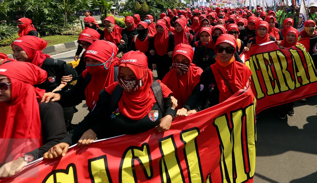 Massa buruh dan pekerja dari berbagai daerah membentangkan spanduk dalam peringatan May Day atau Hari Buruh Internasional di Jalan MH Thamrin, Jakarta, Senin (1/5). Massa buruh berjalan sambil membawa poster-poster tuntutan. (Liputan6.com/Johan Tallo)