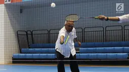 Menteri PUPR, Basuki Hadimuljono mengembalikan kok saat bertanding bulu tangkis disela kunjungannya di Training Facility Gelora Bung Karno Jakarta, Kamis (10/5). Basuki meninjau kesiapan fasilitas dan prasarana Asian Games 2018 (Liputan6.com/Angga Yuniar)