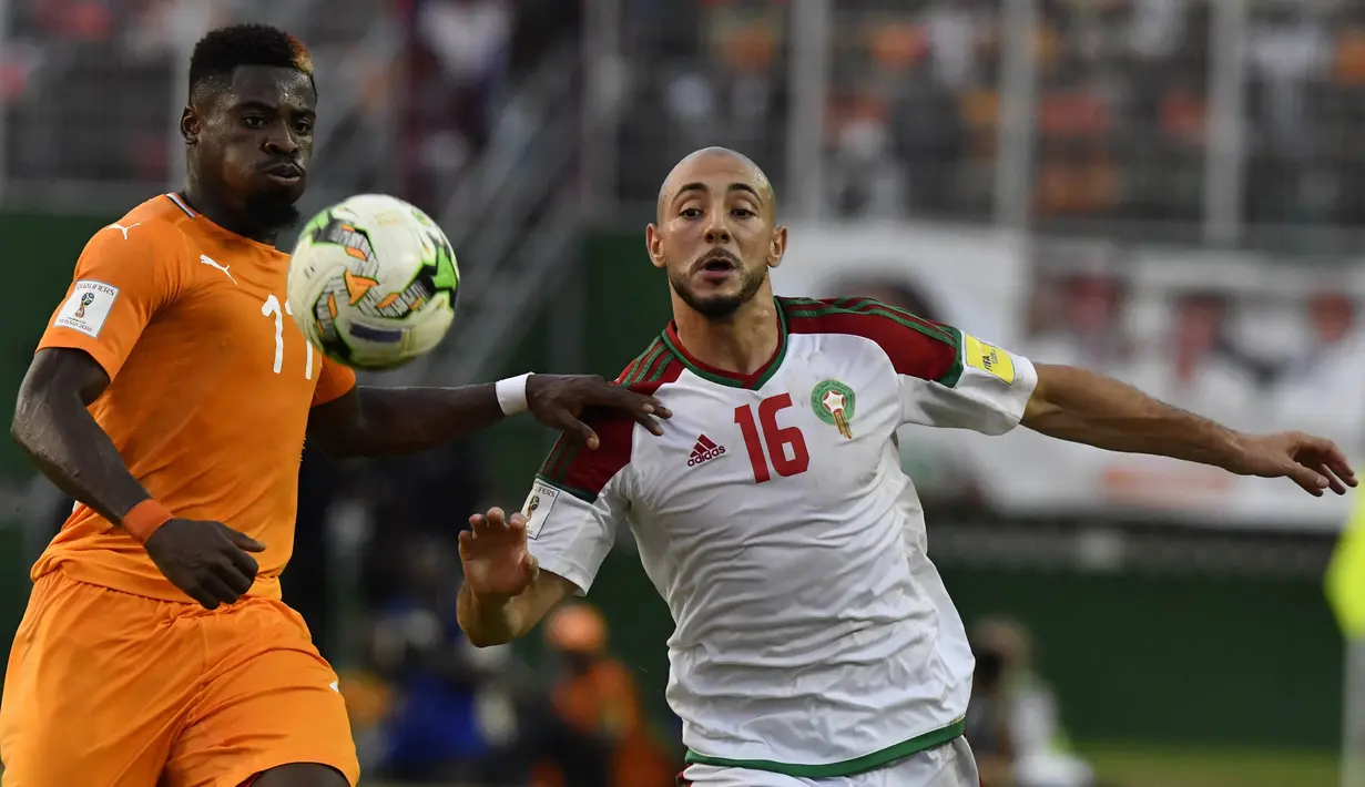 Bek Pantai Gading, Serge Aurier, mengamankan bola dari gelandang Maroko, Noureddine Amrabat, pada Kualifikasi Piala Dunia 2018 di Stadion Félix Houphouët-Boigny, Abidjan, Sabtu (11/11/2017). Pantai Gading kalah 0-2 dari Maroko. (AFP/Issouf Sanogo)