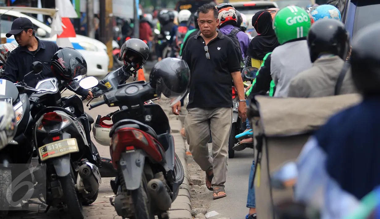 Seorang pejalan kaki terpaksa menggunakan bahu jalan di Jalan Juanda, Bekasi, 4 Oktober 2016. Hak pejalan kaki di Kota Bekasi terampas karena trotoar yang seharusnya digunakan pejalan kaki menjadi lahan parkir kendaraan bermotor. (Foto: Fajar)