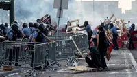 Polisi menyingkirkan barikade yang dibuat demonstran saat unjuk rasa atas kematian George Floyd oleh polisi di luar Third Police Precinct, Minneapolis, Minnesota, Amerika Serikat, Rabu (27/5/2020). Kematian George Floyd memicu kerusuhan di Minneapolis. (Kerem Yucel/AFP)