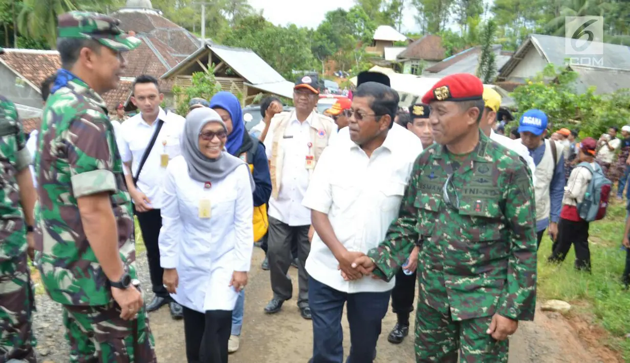 Menteri Sosial Idrus Marham bersalaman dengan Mayor Inf Usman saat mendatangi lokasi terdampak gempa yang mengguncang sejumlah wilayah Jawa Barat dan Banten di Desa Citalahap, Kabupaten Lebak, Bogor (23/1). (LIputan6.com/Pool/Kopassus)