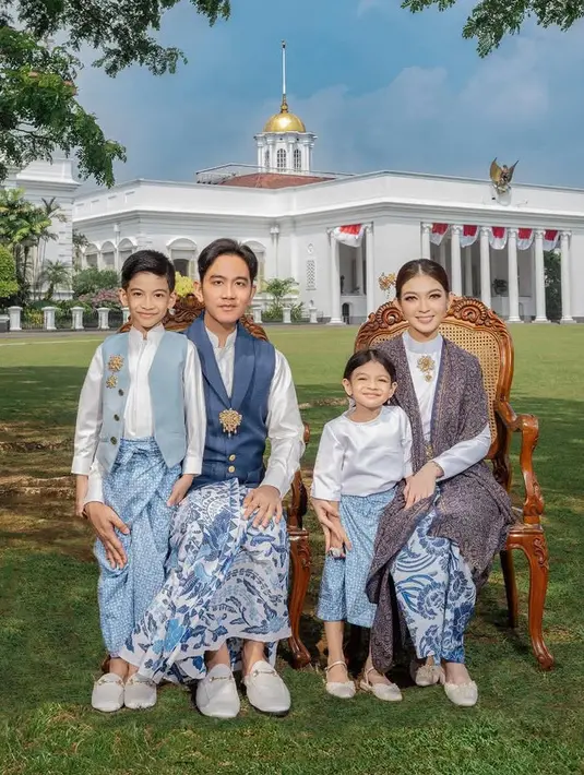 Keluarga Gibran Rakabuming yang kini menjabat sebagai Wakil Presiden juga berfoto di depan istana Bogor. Gibran mengenakan vest biru dipadukan inner kemeja putih dan bawahan kain batik serasi dengan Selvi. Selvi mengenakan inner atasan lengan panjang putih dengan bros emas dipadukan selendang batik. Kedua anaknya kompak mengenakan pakaian bernuansa putih dan baby blue. [@riomotret]
