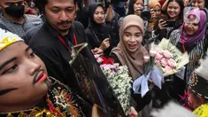 Siti Atiqoh Supriyanti menghadiri acara Hari Disabilitas Internasional yang diselenggarakan oleh Komunitas Disabilitas Tunarungu Indonesia di Bumi Pospera, Cipinang, Jakarta, Minggu (3/12/2023). Atiqoh tampak bahagia disambut oleh para penyandang disabilitas dengan rangkaian bunga. (Liputan6.com/Herman Zakharia)