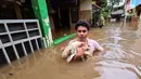 Warga menyelamatkan ayam peliharaannya saat banjir melanda kawasan pemukiman Jalan Bango, Pondok Labu, Jakarta Selatan, Sabtu (20/2/2021). Banjir akibat luapan Kali Krukut yang melanda sejak semalam menyebabkan pemukiman tergenang hingga dua meter. (merdeka.com/Arie Basuki)