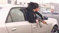 Wanita itu memegang senapan otomatis sambil mencondongkan tubuh ke luar jendela Cadillac. Pic: Polisi San Francisco/@SFTrafficSafety