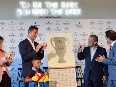 Cristiano Ronaldo saat meresmikan pembukaan Pestana Hotel bersama anaknya Cristiano Ronaldo Jr. dan CEO Pestana Hotel Grup, Dionisio Pestana (2kanan) dan Wali Kota Madeira, Miguel Albuquerque (kanan), di Kepulauan Madeira, (22/7/2016). (AFP/Joana Sousa)