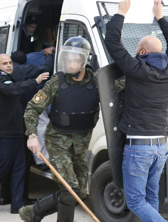 Polisi Palestina mencegah demonstran mendekati sebuah mobil yang membawa delegasi para politikus AS yang tengah mengunjungi Ramallah di Tepi Barat, Kamis (22/2). Saat mereka pergi, delegasi AS dilempari telur oleh para demonstran. (ABBAS MOMANI/AFP)