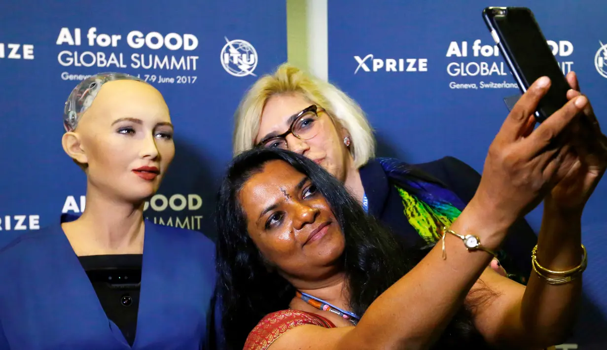 Pengunjung melakukan foto selfie dengan Robot Sophia diperkenalkan di sela acara KTT Global "AI for Good" di ITU di Jenewa, Swiss (7/6). Robot yang memiliki kecerdasan buatan ini juga bisa menjawab pertanyaan dengan lancar. (Reuters/Denis Balibouse)