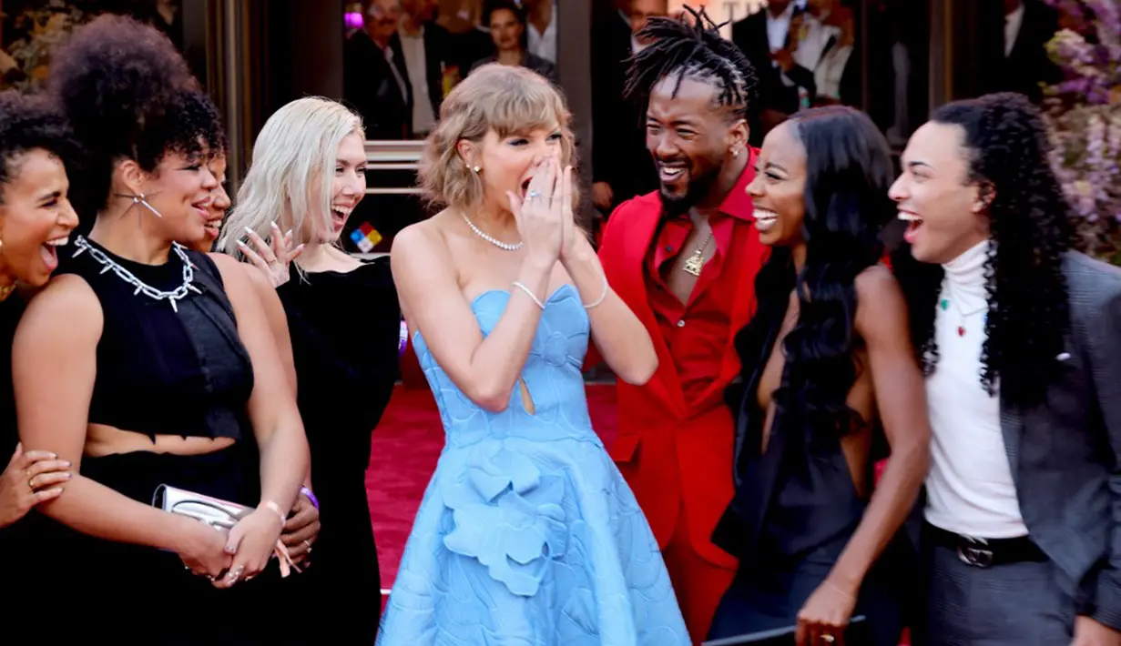 Dilansir dari ET, Taylor Swift tiba pada acara tersebut mengenakan sebuah gaun biru yang didesain oleh Oscar De La Renta. Rambutnya yang panjang ditata menjadi lebih pendek ala vintage. (Matt Winkelmeyer/Getty Images/AFP)