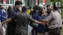 Petugas keamanan mengadang sejumlah mahasiswa UNY yang akan menggelar aksi di depan Gedung Kemendikbud, Jakarta, Jumat (10/2/2023). Dengan memaksa masuk untuk melakukan aksi di dalam lingkungan Kemendikbud, mahasiswa UNY memberikan baju dansa sebagai bentuk protes terkait mahalnya biaya kuliah di Indonesia. (Liputan6.com/Faizal Fanani)