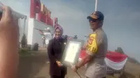 Kapolda Jabar Irjen Pol. Rudy Sufahriadi, tengah menerima sertifikat penghargaan rekor dunia penerbangan Paralayang terbanyak di dunia versi RHR (Liputan6.com/Jayadi Supriadin)