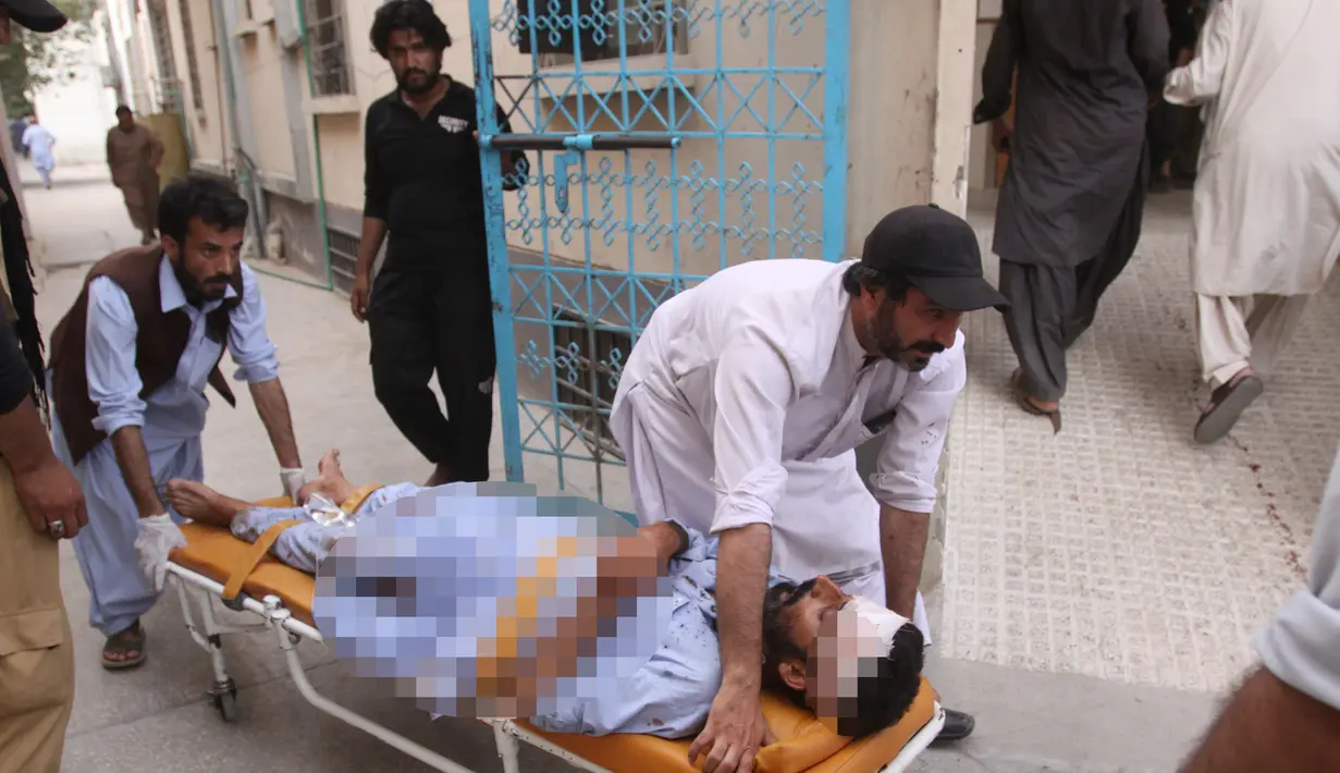 Warga membawa seorang yang terluka akibat serangan bom bunuh diri ke rumah sakit di Quetta, Pakistan, (13/7). Bom bunuh diri tersebut menewaskan 128 orang dan melukai sekitar 150 orang. (AP Photo/Arshad Butt)