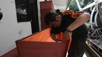 Petugas menyelesaikan pembuatan peti mati khusus jenazah virus corona atau Covid-19 di Dinas Pertamanan dan Pemakaman Jakarta, Sabtu (28/3/2020). Peti mati korban meninggal akibat corona Covid-19 itu dilapisi kantong jenazah dan kain kafan untuk mencegah penyebaran virus. (Liputan6.com/Angga Yuniar)