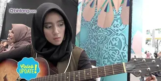 Salah satu peserta audisi Puteri Muslimah Indonesia 2017 membawa gitar. 
