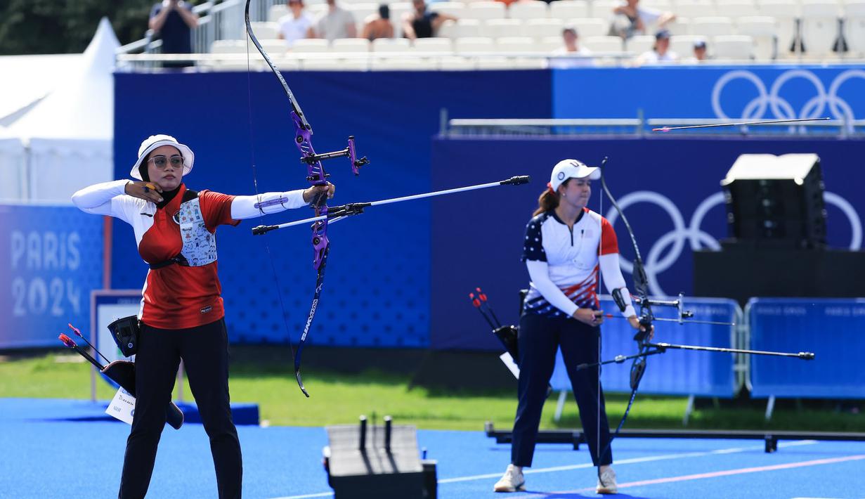 <p>Atlet panahan putri Indonesia, Diananda Choirunisa (kiri) melepaskan anak panah saat menghadapi wakil Amerika Serikat, Catalina Gnoriega pada babak 32 besar nomor individual putri Olimpiade Paris 2024 di Les Invalides Arena, Paris, Selasa (30/7/2024). Diananda Choirunisa menang 6-5. (Dok. NOC Indonesia/Naif Muhammad Al'as)</p>