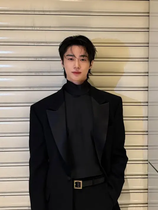 Byeon Woo Seok tampil mengenakan inner turtle neck yang diserasikan dengan outer jas oversize. Menggunakan belt hitam buckle emas dan celana hitam panjangnya. [@byeonwooseok]