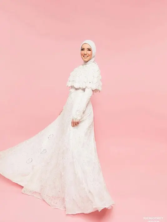 Tema kedua Tya juga tampil anggun dengan hijab dan gaun bernuansa serba putih. Pesonanya bikin pangling! (Instagram/tyaariestya).