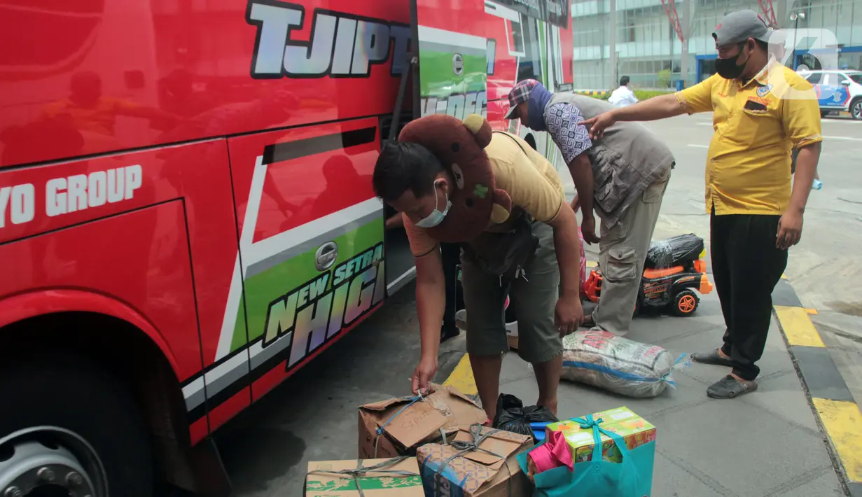 Calon penumpang memasukkan barang bawaannya ke dalam bagasi bus di Terminal Pulo Gebang, Jakarta, Selasa (4/5/2021). Jumlah penumpang yang berangkat dari Terminal Pulo Gebang terus meningkat jelang diberlakukannya aturan larangan mudik Lebaran mulai 6 Mei-17 Mei 2021. (Liputan6.com/Herman Zakharia)