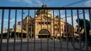 Pesepeda melewati Stasiun Flinders Street yang kosong selama lockdown atau penguncian wilayah di Melbourne, Kamis (6/8/2020). Negara bagian Victoria, hotspot COVID-19 di Australia, melakukan lockdown dan menutup bisnis ritel sebagai upaya mencegah penyebaran virus corona. (AP Photo/Andy Brownbill)