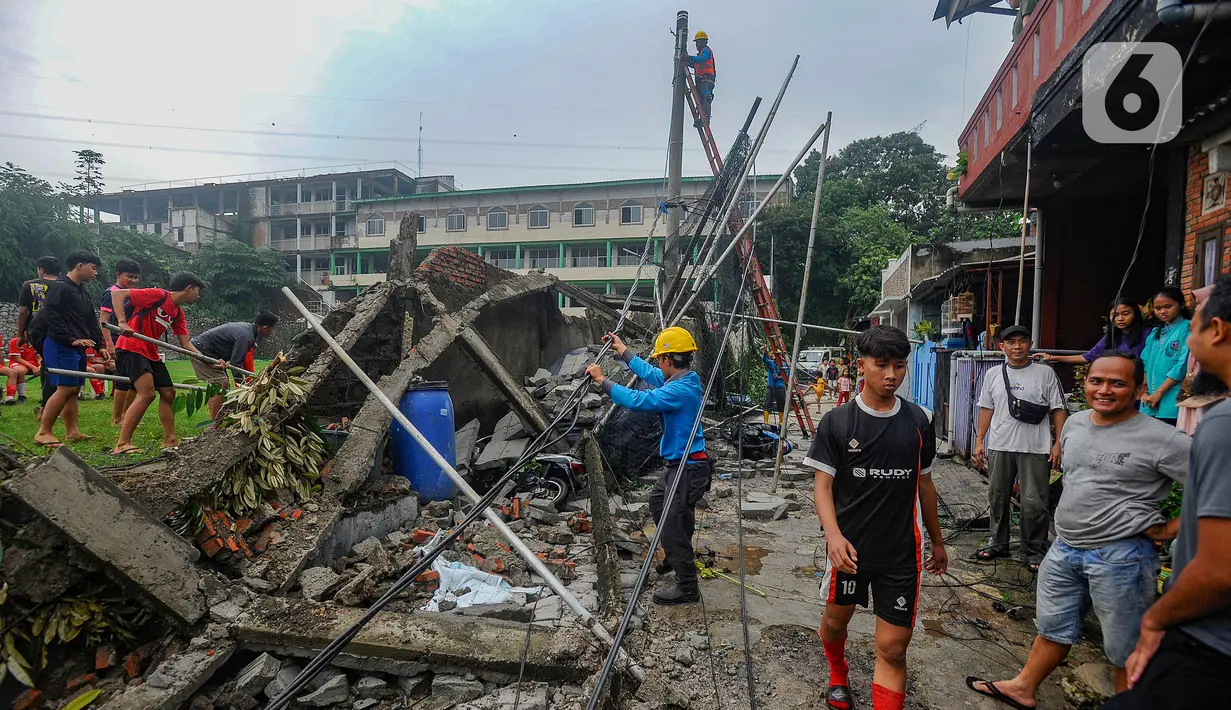 Petugas PLN memperbaiki jaringan listrik saat tembok lapangan Sekolah Amec  roboh di Pamulang Elok, Tangerang selatan, Banten, Jumat (8/12/2023). (merdeka.com/Arie Basuki)