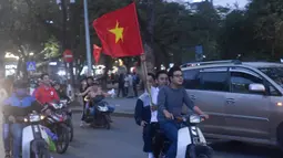 Sejumlah warga konvoi merayakan keberhasilan Vietnam mengalahkan Qatar pada semifinal Piala AFC U-23 di Hanoi, Rabu (23/1/2018). Vietnam berhasil lolos ke final untuk menantang pemenang antara Uzbekistan dan Korea Selatan. (AFP/Hoang Dinh Nam)