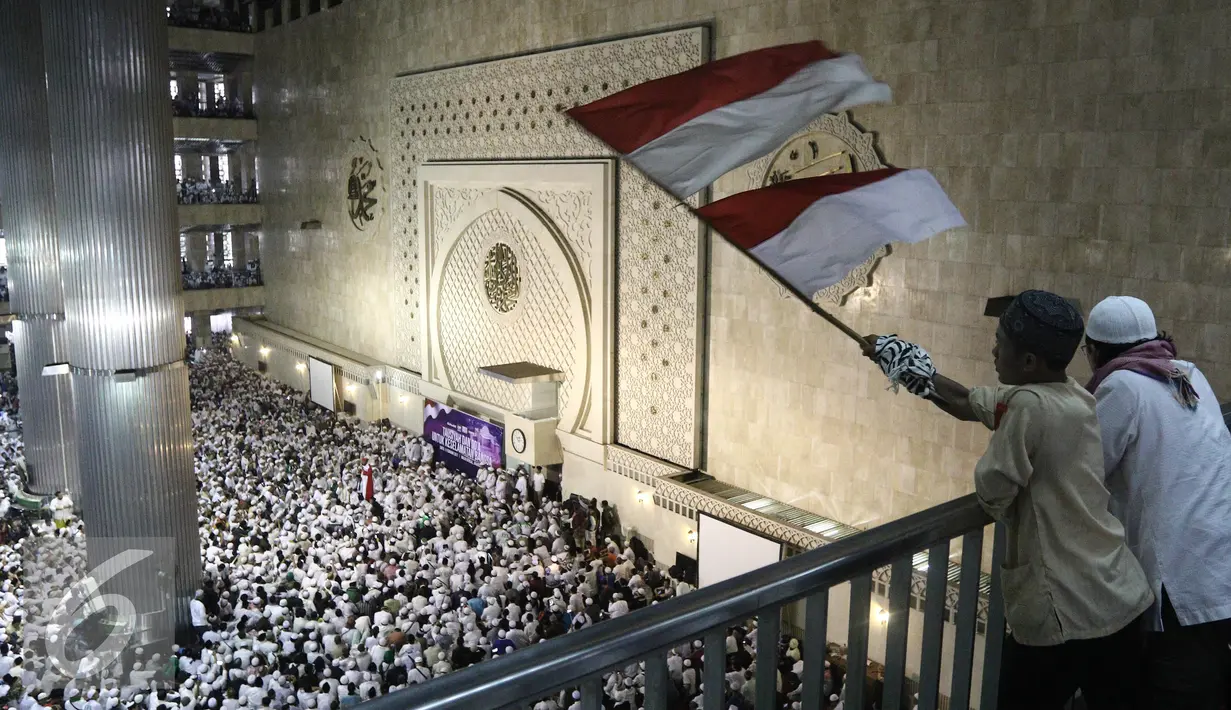 Peserta aksi mengibarkan bendera merah putih di Masjid Istiqlal, Jakarta, Sabtu (11/2). Massa yang kebanyakan mengenakan baju putih-putih ini datang dengan menggunakan kendaraan pribadi dan angkutan umum. (Liputan6.com/Herman Zakharia)