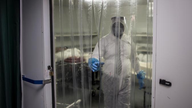 Seorang pengurus keluar dari ruang pendingin tempat penyimpanan jenazah pasien virus corona COVID-19 di rumah duka AVBOB, Soweto, Afrika Selatan, 21 Juli 2020. (MARCO LONGARI/AFP)