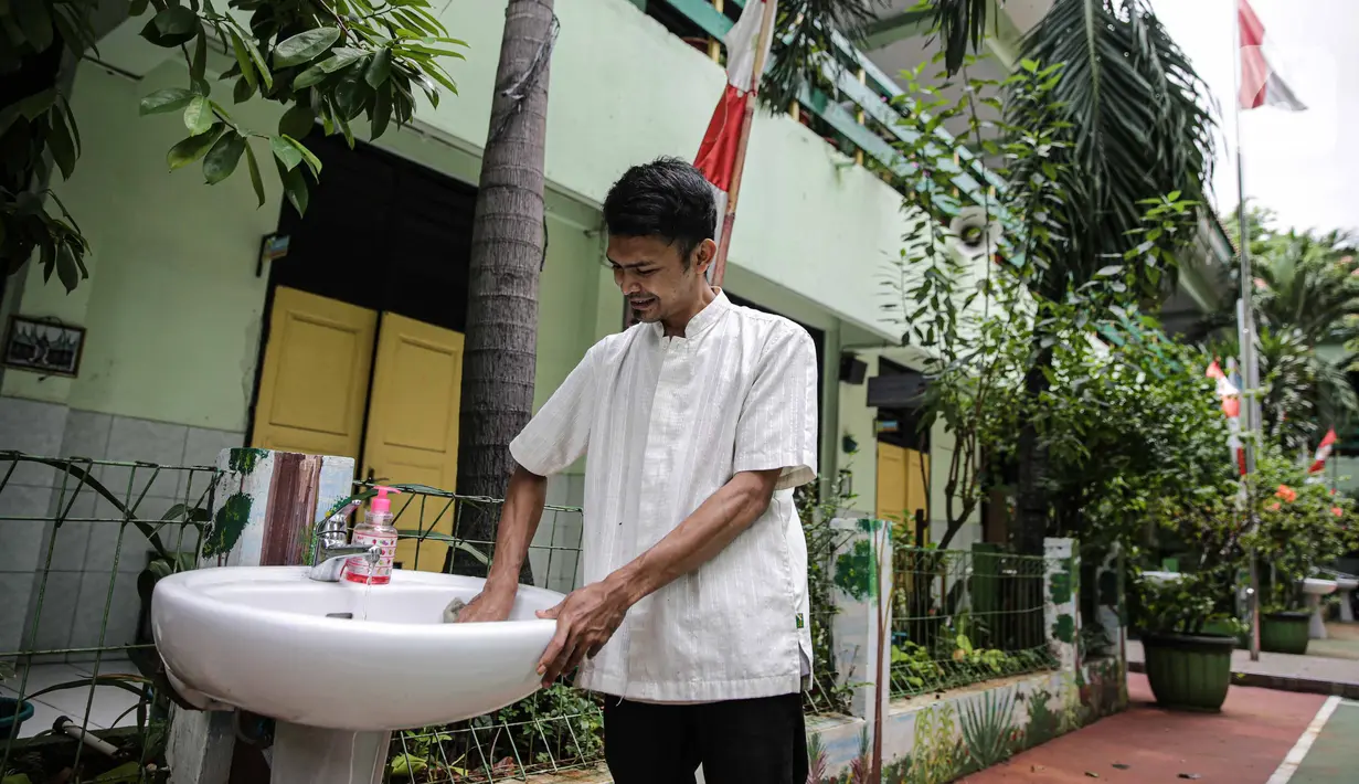Petugas membersihkan tempat cuci tangan di SD Negeri Kota Bambu 03/04, Jakarta, Sabtu (21/11/2020). Pemerintah pusat memberikan kewenangan pemerintah daerah membuka sekolah dan melakukan pembelajaran tatap muka pada semester genap tahun ajaran 2020/2021. (Liputan6.com/Faizal Fanani)