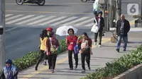Warga beraktivitas menggunakan payung saat suhu udara mencapai 35 derajat Celcius di Kawasan Jalan MH Thamrin, Jakarta, Selasa (22/10/2019). (Liputan6.com/Helmi Fithriansyah) Event