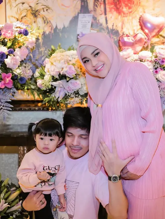 Aurel Hermansyah, Atta Halilintar, dan Ameena pun kompak mengenakan baju pink saat memberi kejutan Ashanty. Tampak Aureld dibalut setelan plisket pink serasi dengan kerudungnya. [@aurelie.hermansyah]
