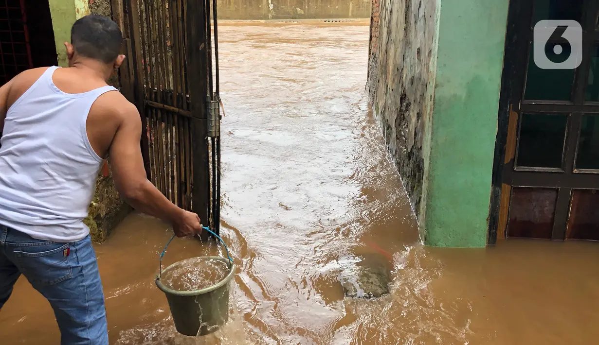 Warga beraktivitas di tengah banjir yang merendam kawasan Kebon Pala, Jakarta Timur, Selasa (25/2/2020). Akibat banjir yang tak kunjung surut, aktivitas warga di kawasan tersebut menjadi terganggu, terlebih dengan adanya pemadaman listrik. (Liputan6.com/Immanuel Antonius)