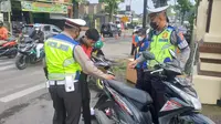 Dua petugas satlantas polres Garut, tengah melakukan pemeriksaan surat kendaraan dalam pelaksanaan operasi Zebra Lodaya 2022 di dekat Mapolres Garut. (Liputan6.com/Jayadi Supriadin)