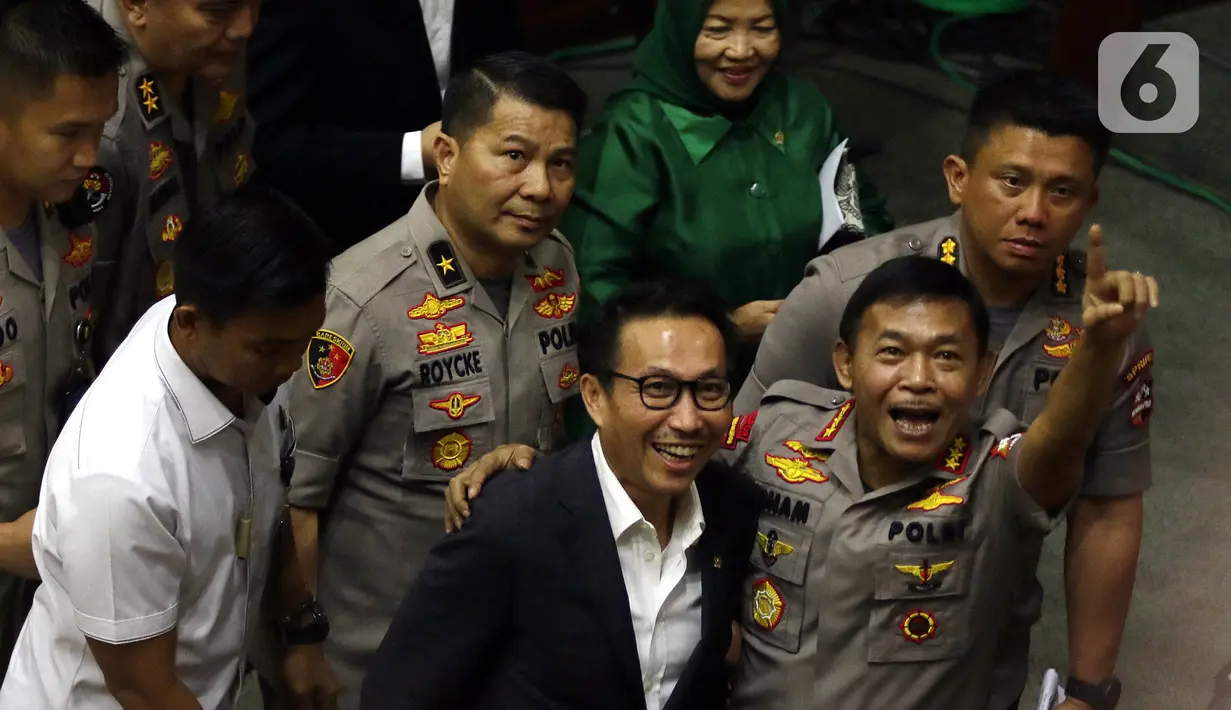 Komjen Pol Idham Azis (kanan) mengacungkan jari kepada wartawan setelah ditetapkan sebagai Kapolri dalam rapat paripurna di Kompleks Parlemen, Jakarta,  Kamis (31/10/2019). DPR menyetujui Idham Aziz menjadi Kapolri menggantikan Jenderal Polisi (Purn) Tito Karnavian. (Liputan6.com/JohanTallo)