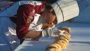 Suasana pembuatan kue raja sepanjang 2.063,43 meter di Saltillo, Negara Bagian Coahuila, Meksiko, 6 Januari 2019. Kue yang dibuat adalah brioche berukuran besar, yang dikenal sebagai "Rosca de Reyes" atau cincin raja. (Julio Cesar AGUILAR/AFP)