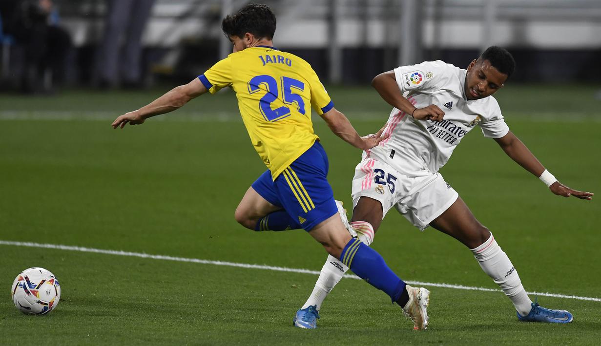 Pemain Real Madrid, Rodrygo, berebut bola dengan pemain Cadiz, Jairo Izquierdo, pada laga Liga Spanyol di Stadion Ramon de Carranza, Rabu (22/4/2021). Real Madrid menang dengan skor 3-0. (AP Photo/Jose Breton)