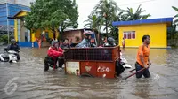 Penyedia jasa gerobak mengangkut warga dan motornya untuk menyeberangi banjir di Jalan Gunung Sahari, Jakarta Pusat, Selasa (21/2). Hujan deras yang mengguyur sejak Selasa dini hari membuat sebagian wilayah di Jakarta banjir. (Liputan6.com/Faizal Fanani)